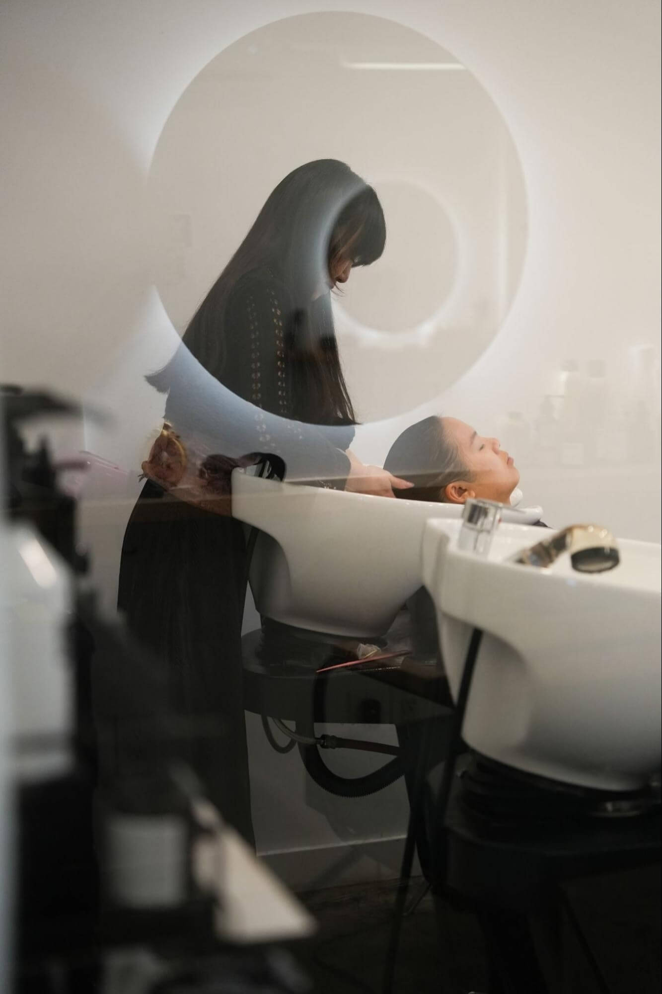 A stylist washing a client's hair at Salon Freyja, a hair treatment salon in Montreal's Little Italy